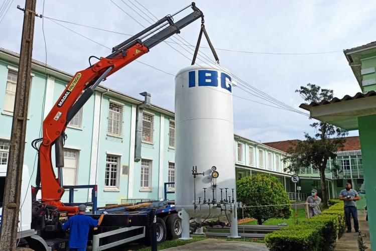 Guindaste descarrega tanque de oxigênio nas instalações do hospital.